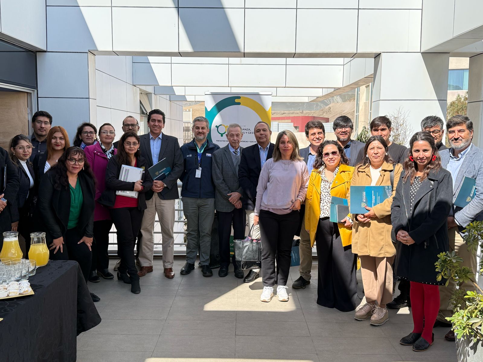 Grupo de personas en un salón exterior con luz de día, en la primera sesión del Consejo Asesor del Centro de Gobernanza, Políticas y Gestión Pública