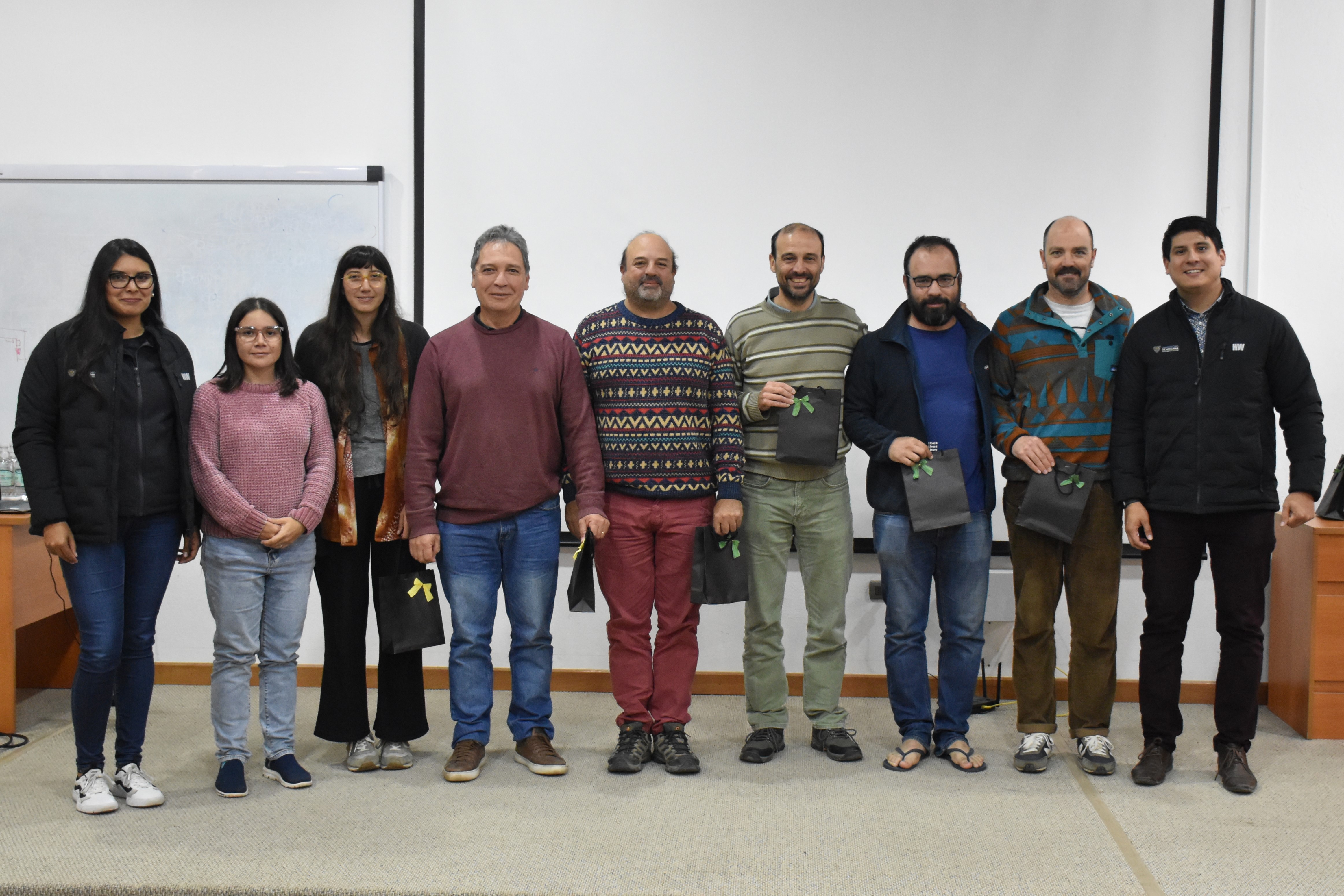 Nueve académicos de una jornada de charlas científicas sobre Geología posan para fotografía en un auditorio